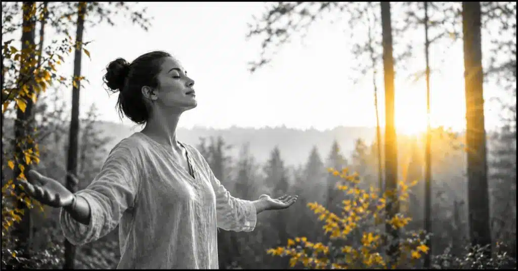 woman practicing spiritual affirmations for self-confidence in nature at sunrise.'